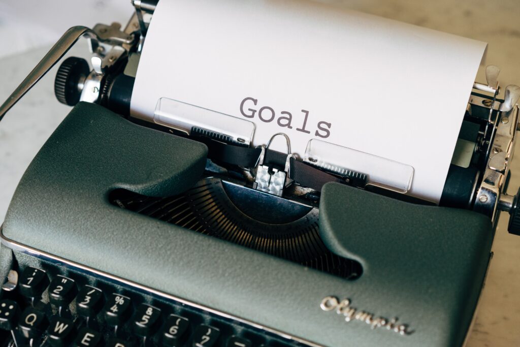 Typewriter with a piece of paper. On the paper the word Goals is typed.